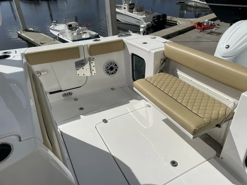 Slide: The Image of 2021 Sportsman 302 OPEN boat interior with tan seating and speaker, docked at marina. - 17