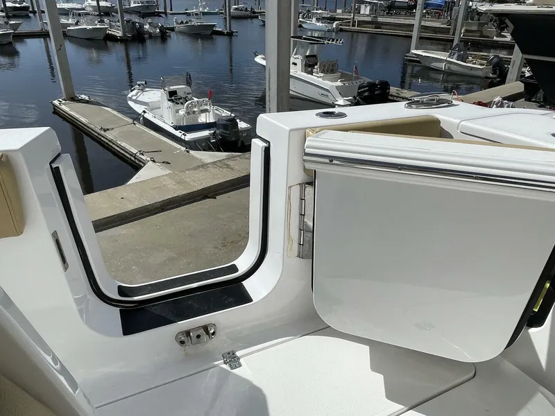 Slide: The Image of 2021 Sportsman 302 OPEN boat at marina, open side door, docked boats in background. - 19