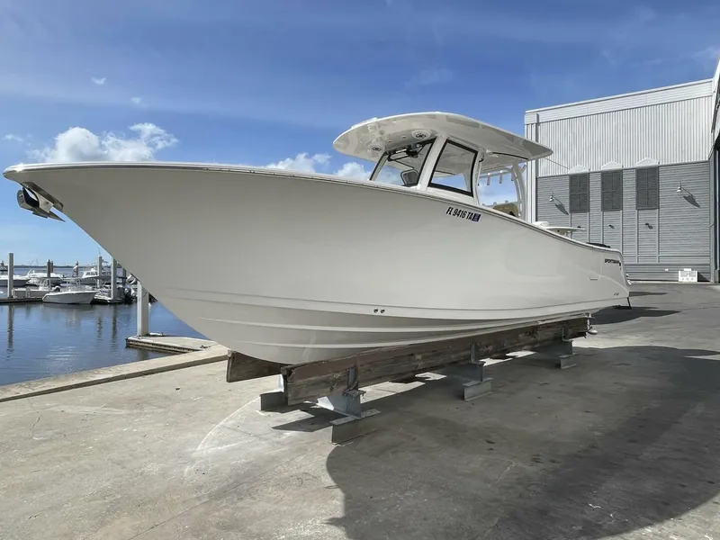 Slide: The Image of 2021 Sportsman 302 OPEN boat on dry dock, marina background, clear sky. - 2