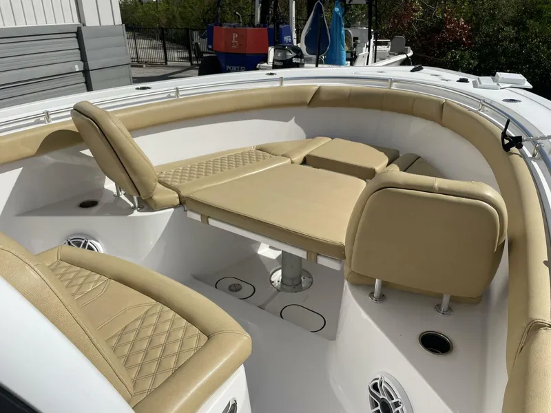Slide: The Image of 2021 Sportsman 302 OPEN boat interior with beige cushioned seating and table. - 9