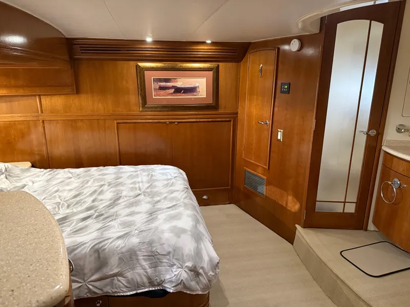 Slide: The Image of Luxurious 1998 Carver 530 VOYAGER yacht bedroom with wood paneling and cozy bedding. - 38