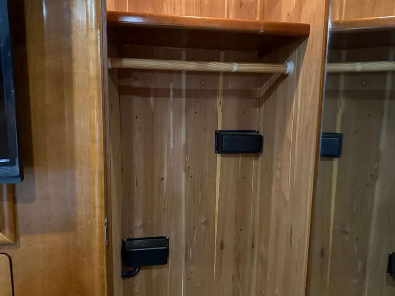 Slide: The Image of Wooden closet interior in 1998 Carver 530 VOYAGER yacht, featuring a hanging rod and shelf. - 39