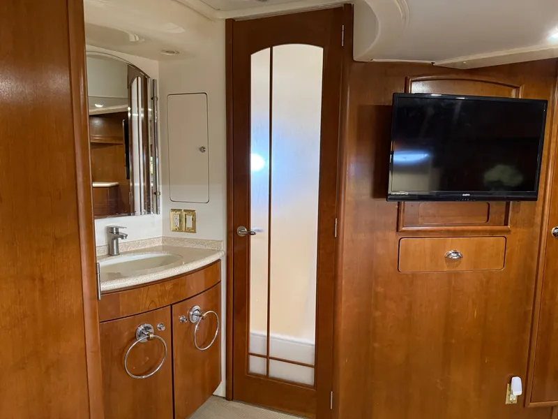 Slide: The Image of 1998 Carver 530 VOYAGER interior with wooden cabinetry, sink, and mounted TV. - 43