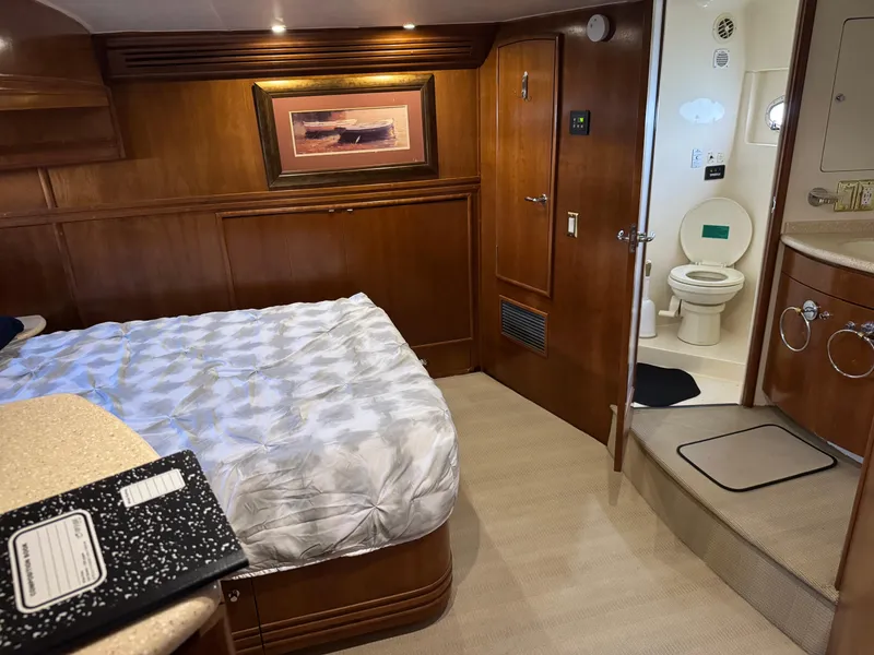 Slide: The Image of Luxurious 1998 Carver 530 VOYAGER yacht bedroom with ensuite bathroom and elegant wood finishes. - 5