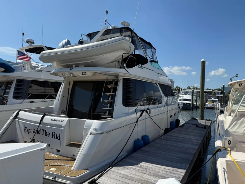 Slide: The Image of 1998 Carver 530 Voyager yacht docked at marina under clear blue sky. - 7