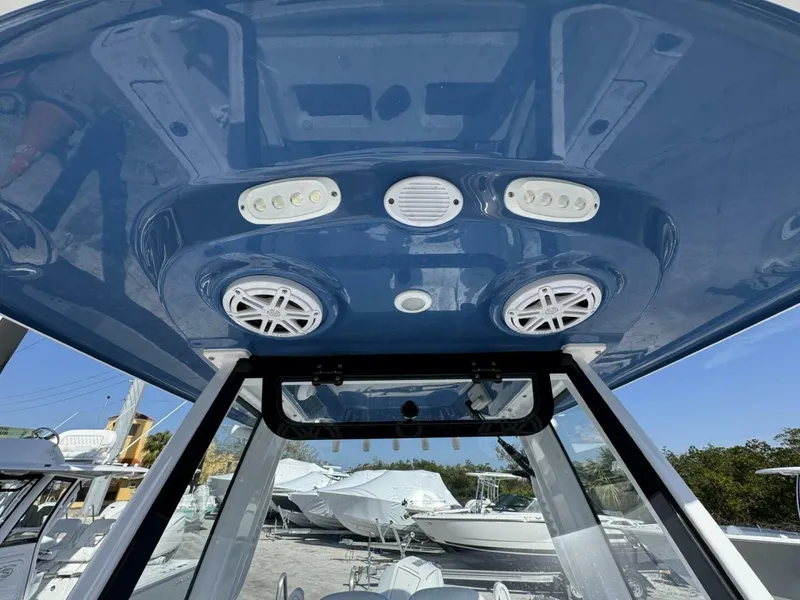 Slide: The Image of 2025 Sportsman 212 Open boat with blue T-top, featuring speakers and LED lights. - 14