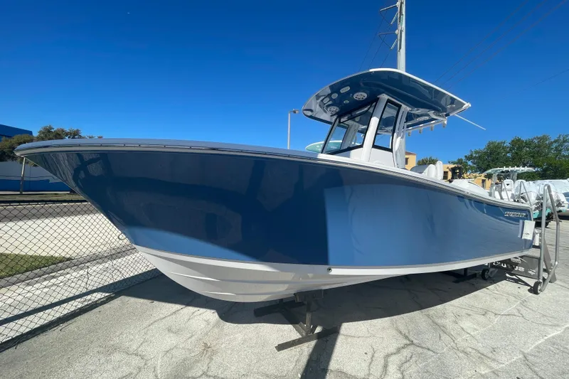 Slide: The Image of 2025 Sportsman Open 212 Center Console boat in blue, parked outdoors under clear sky. - 16