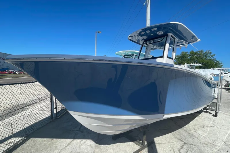 Slide: The Image of 2025 Sportsman Open 212 Center Console boat in a marina under clear blue sky. - 17