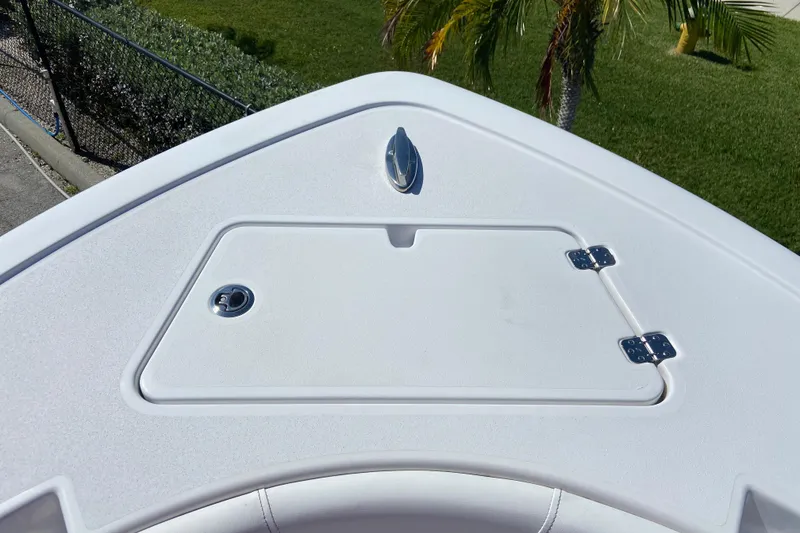 Slide: The Image of Bow storage compartment on 2025 Sportsman Open 212 Center Console boat, with lush greenery background. - 19