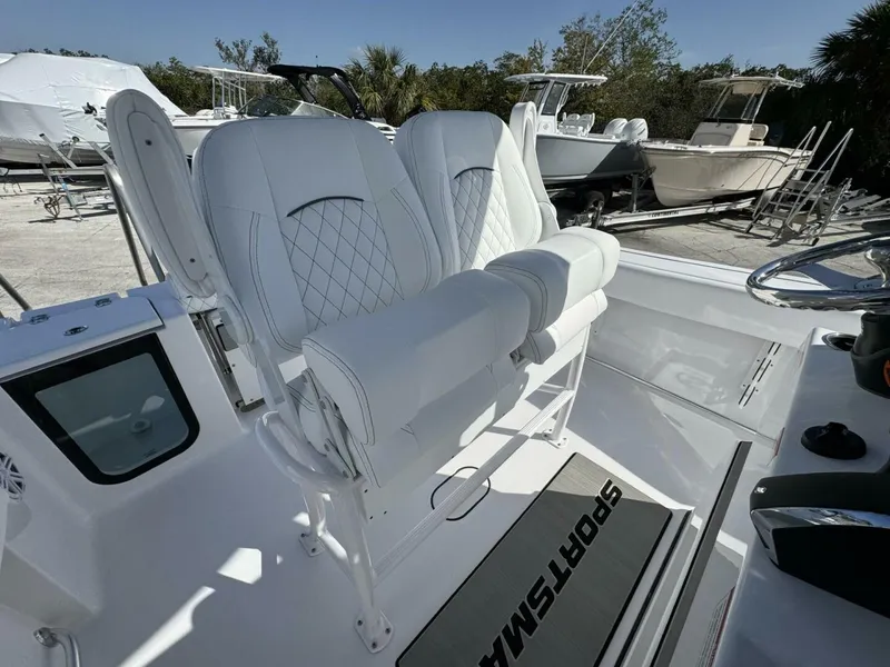 Slide: The Image of 2025 Sportsman 212 Open boat interior with white cushioned seating and steering wheel. - 7