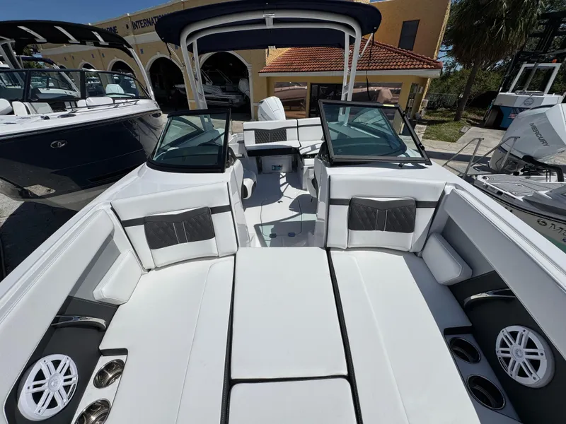 Slide: The Image of 2024 Monterey M225 boat interior with white seating, cup holders, and speakers. - 12