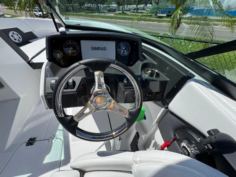 Slide: The Image of 2024 Monterey M225 boat dashboard with steering wheel and Simrad display. - 7