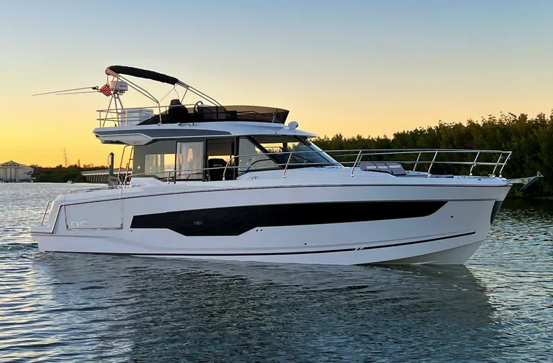 The Image of 2025 Jeanneau 1295 FLY yacht cruising at sunset on calm waters. - 0