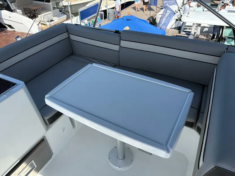 Slide: The Image of Flybridge seating area on 2025 Jeanneau 1295 FLY yacht with table and cushions. - 11