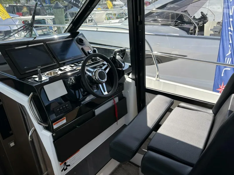 Slide: The Image of Helm of 2025 Jeanneau 1295 FLY yacht with modern controls and seating. - 12