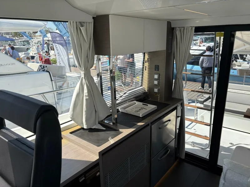 Slide: The Image of Interior of 2025 Jeanneau 1295 FLY yacht, featuring modern kitchen and large windows. - 13