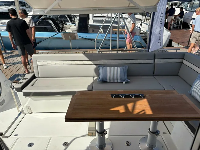 Slide: The Image of Luxurious Jeanneau 1295 FLY 2025 yacht interior with elegant seating and wooden table. - 16