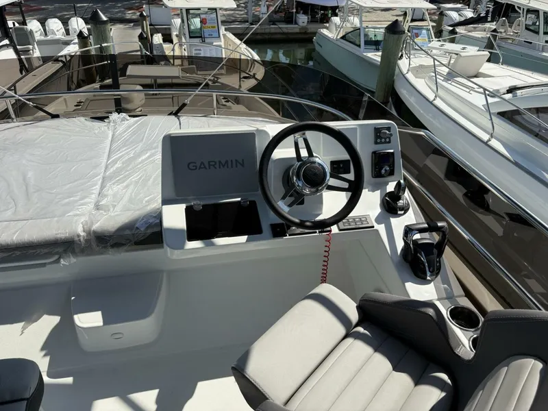 Slide: The Image of 2025 Jeanneau 1295 FLY yacht helm with Garmin navigation system and comfortable seating. - 5