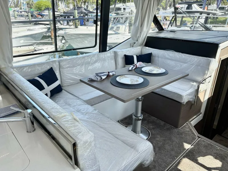 Slide: The Image of 2025 Jeanneau 1295 FLY yacht interior with dining area and cushioned seating. - 15