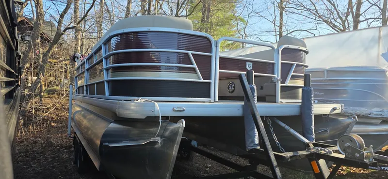 Slide: The Image of 2022 Godfrey Sweetwater 2286 FS pontoon boat on trailer, surrounded by trees. - 1