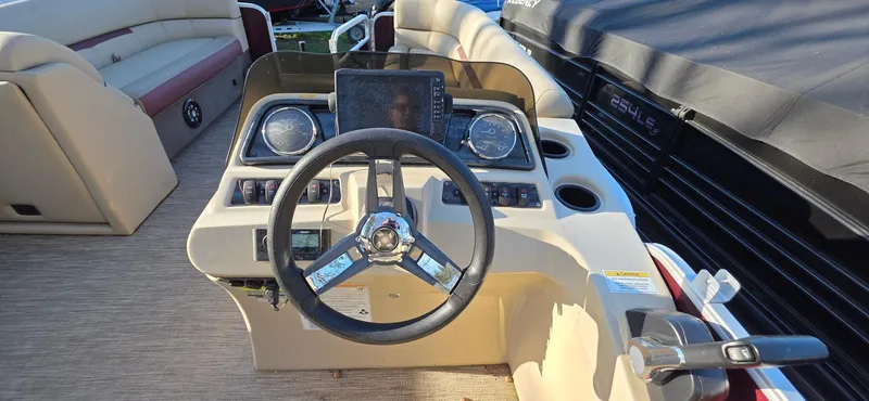 Slide: The Image of 2022 Godfrey Sweetwater 2286 FS boat dashboard with steering wheel and controls. - 10