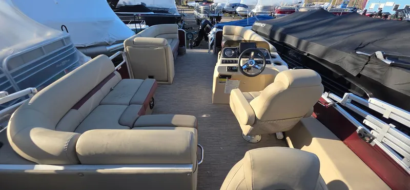 Slide: The Image of 2022 Godfrey Sweetwater 2286 FS pontoon boat interior with beige seating and steering console. - 11