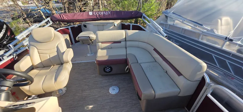 Slide: The Image of 2022 Godfrey Sweetwater 2286 FS pontoon boat interior with beige seating and steering console. - 7