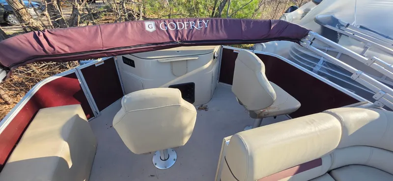 Slide: The Image of 2022 Godfrey Sweetwater 2286 FS boat interior with beige seating and maroon accents. - 8