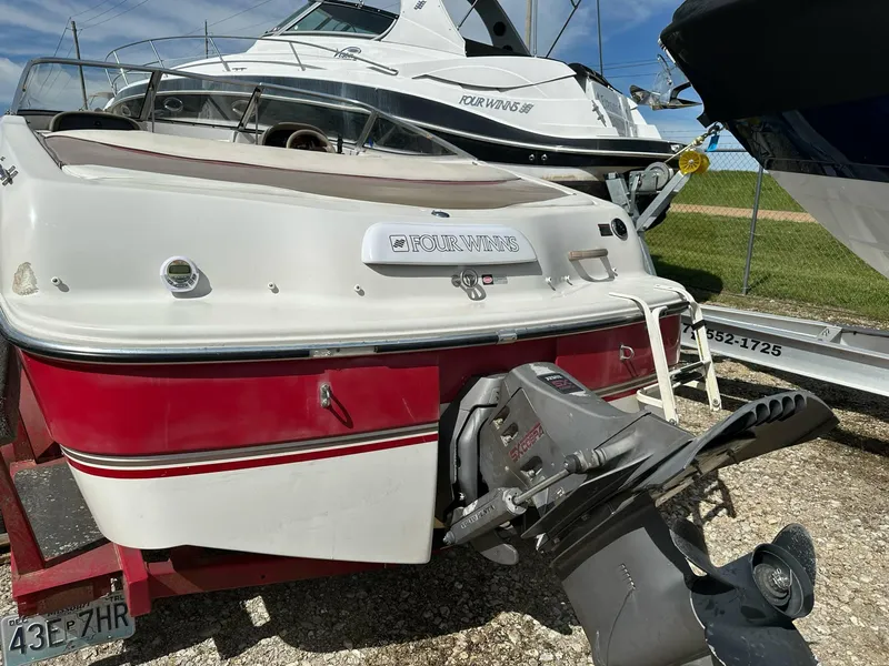 Slide: The Image of 1998 Four Winns 190 Horizon boat with red and white exterior, parked on a trailer. - 14