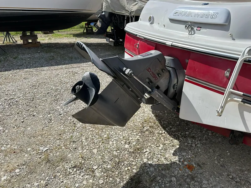 Slide: The Image of 1998 Four Winns 190 Horizon boat with outboard motor, parked on gravel. - 19