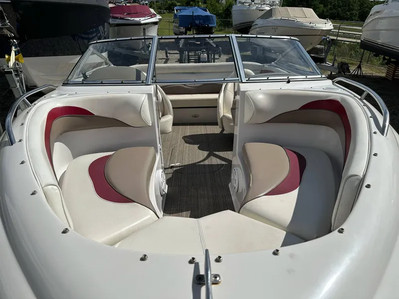 Slide: The Image of 1998 Four Winns 190 Horizon boat interior with red and beige seating, docked outdoors. - 2