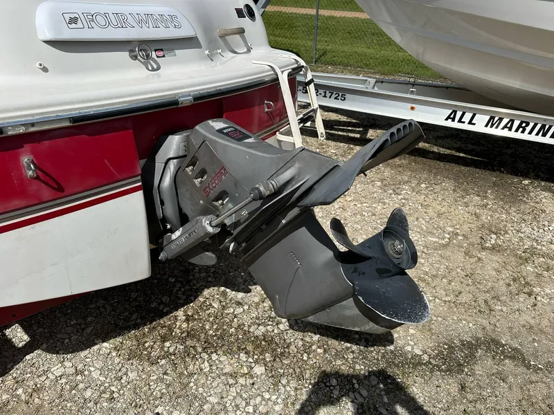 Slide: The Image of 1998 Four Winns 190 Horizon boat stern with outboard motor on gravel. - 24