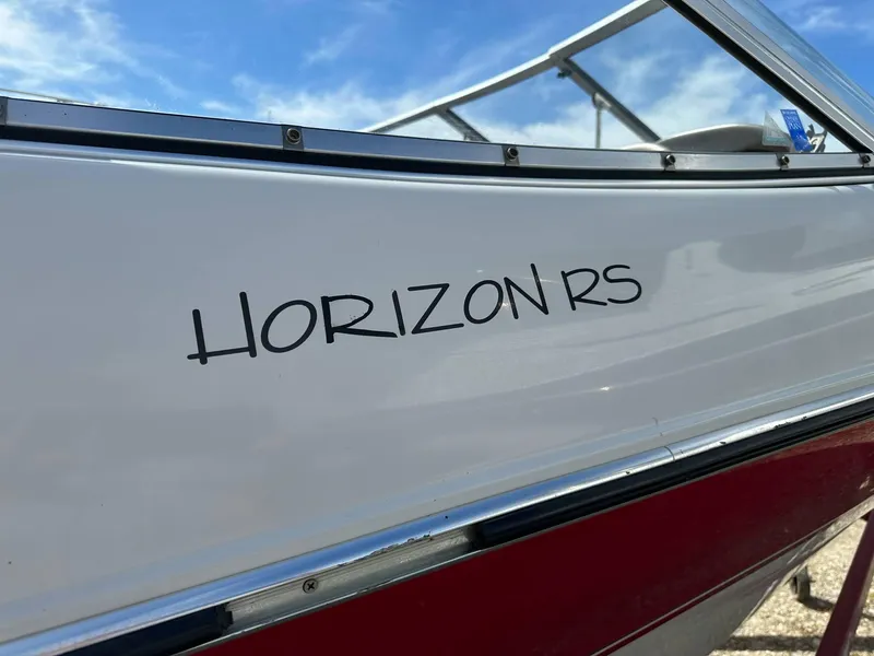 Slide: The Image of 1998 Four Winns 190 Horizon boat with "Horizon RS" text on the side, under blue sky. - 27