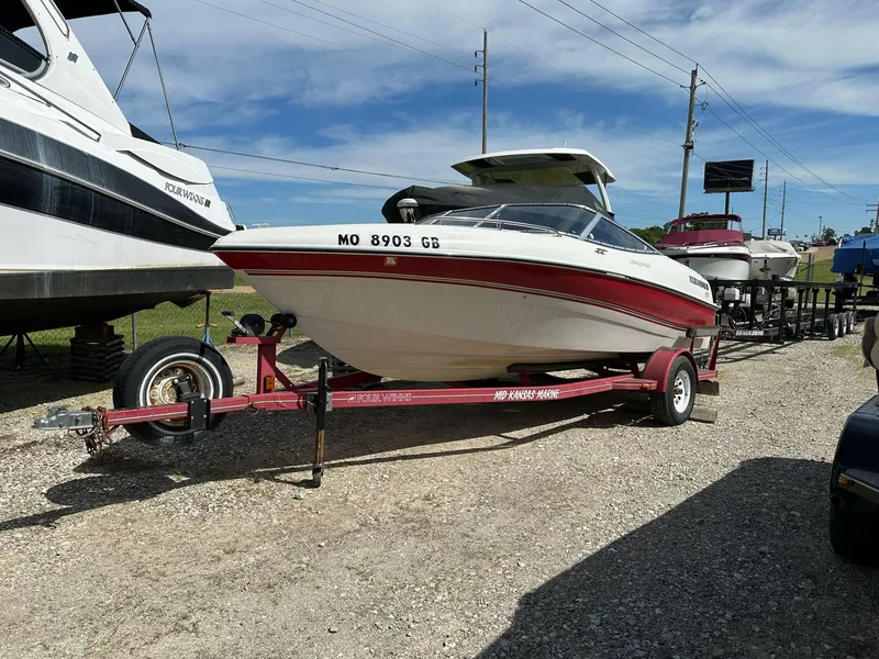 Slide: The Image of 1998 Four Winns 190 Horizon boat on trailer, parked outdoors under a clear sky. - 33