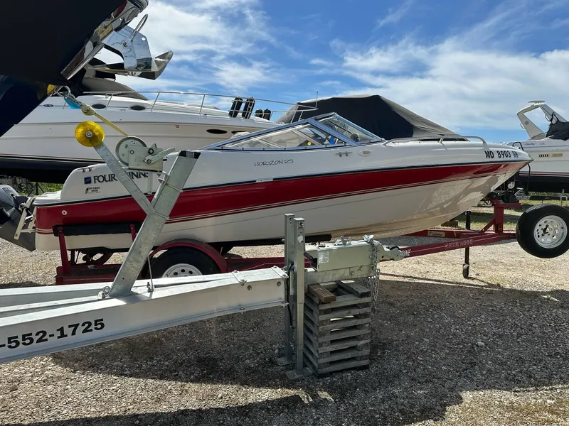 Slide: The Image of 1998 Four Winns 190 Horizon boat on trailer, parked outdoors under a clear blue sky. - 34