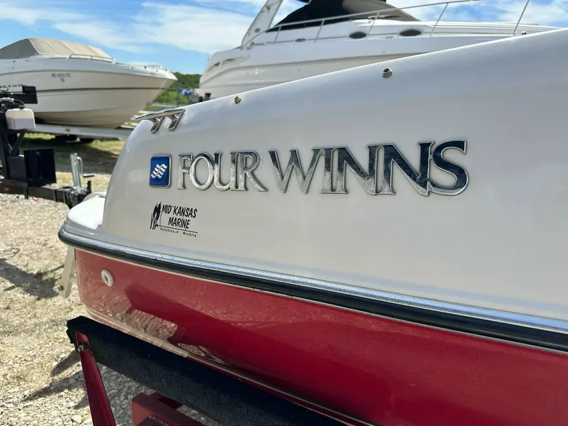 Slide: The Image of 1998 Four Winns 190 Horizon boat with red and white exterior, parked outdoors. - 9