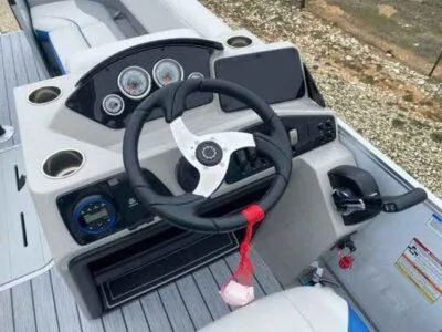 Slide: The Image of 2025 SunCatcher Select 322SS boat dashboard with steering wheel and control panel. - 3