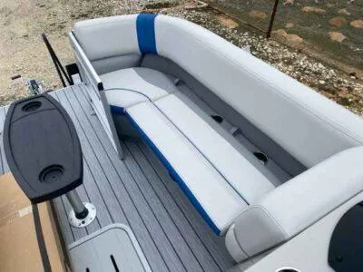 Slide: The Image of 2025 SunCatcher Select 322SS boat interior with gray and blue seating and a small table. - 4