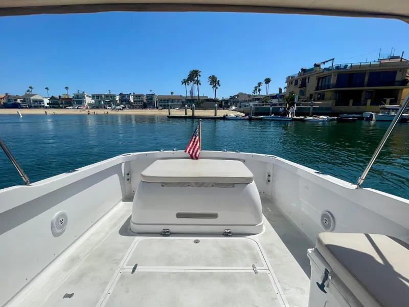Slide: The Image of 1966 Bertram 25 Moppie boat with American flag, docked near waterfront homes and palm trees. - 11