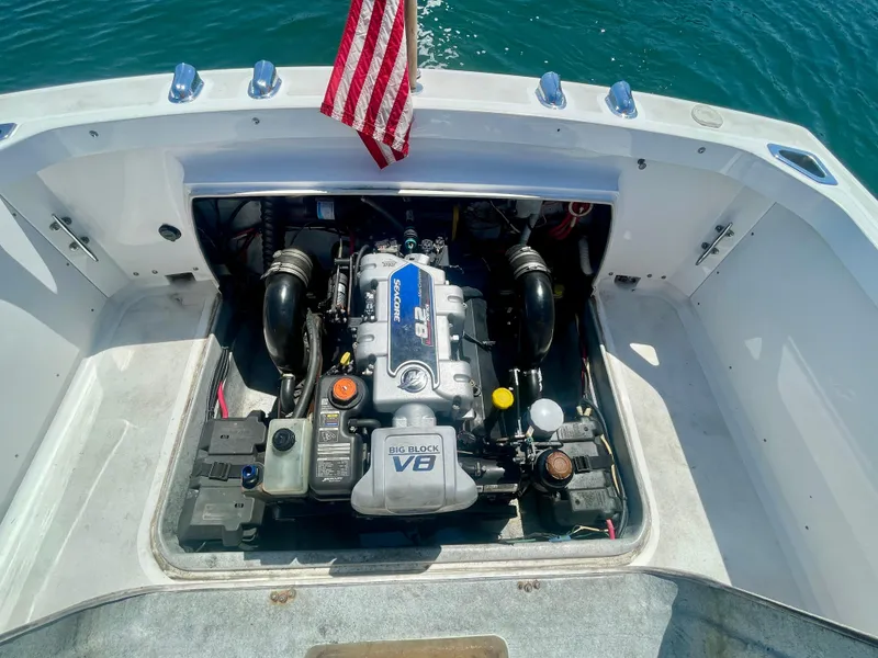 Slide: The Image of 1966 Bertram 25 Moppie boat engine compartment with V8 engine, American flag visible. - 16