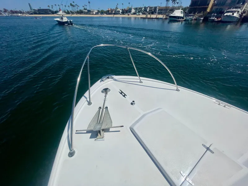 Slide: The Image of 1966 Bertram 25 Moppie boat on water, view from bow, coastal background. - 20