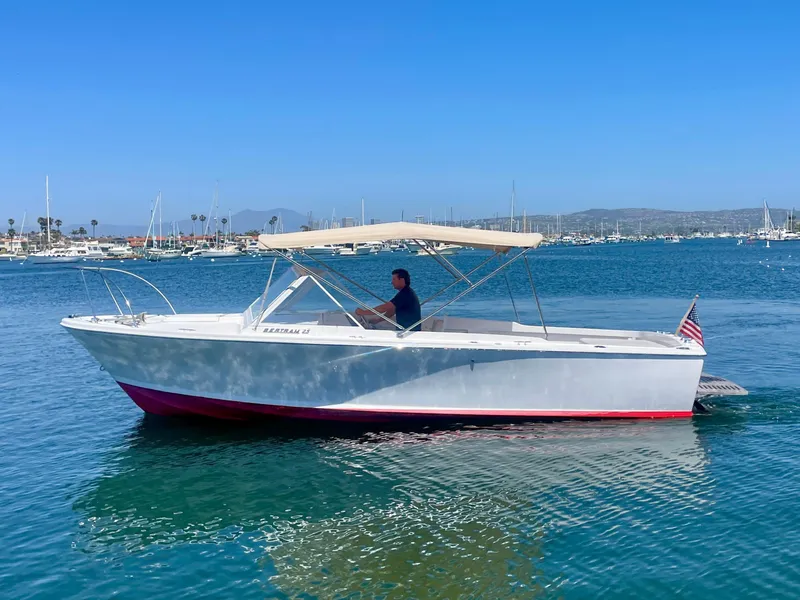 Slide: The Image of 1966 Bertram 25 Moppie boat cruising on a sunny day in a marina. - 3