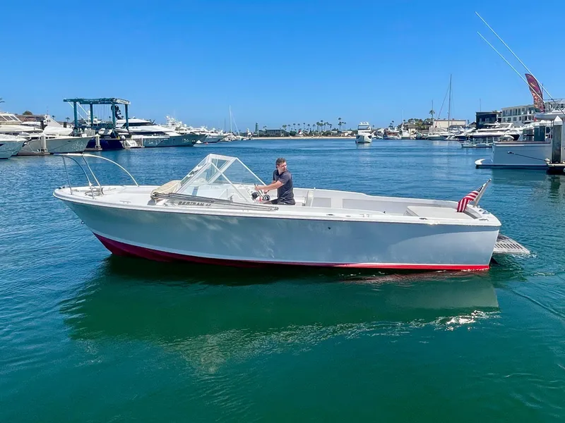 Slide: The Image of 1966 Bertram 25 Moppie boat cruising in a marina under clear blue skies. - 4