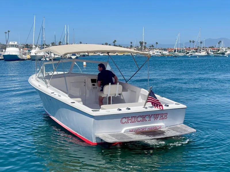 Slide: The Image of 1966 Bertram 25 Moppie boat cruising in Newport Harbor with American flag. - 5