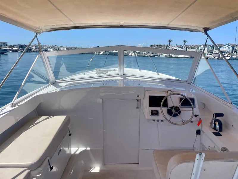 Slide: The Image of 1966 Bertram 25 Moppie boat interior with steering wheel, seating, and marina view. - 6
