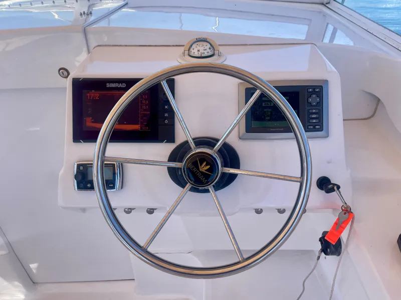 Slide: The Image of Steering wheel and dashboard of a 1966 Bertram 25 Moppie boat with navigation instruments. - 9