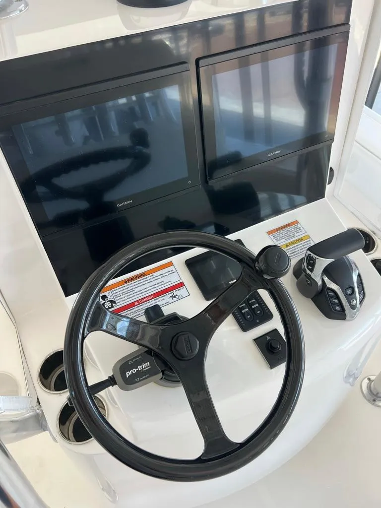 Slide: The Image of 2025 Contender 23 Bay helm with dual screens and steering wheel. - 13