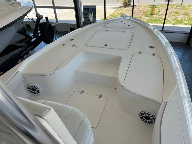 Slide: The Image of 2025 Contender 23 Bay boat interior with white seating and storage compartments. - 6