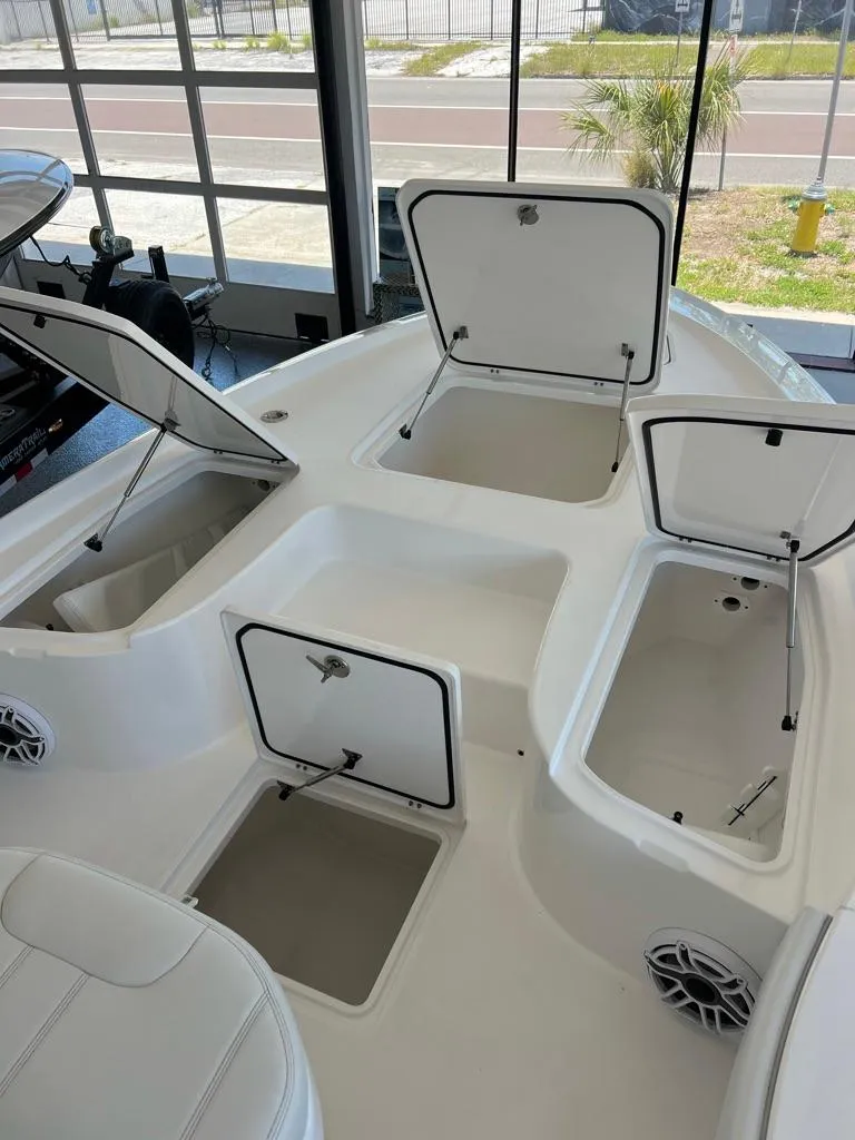 Slide: The Image of 2025 Contender 23 Bay boat interior with open storage compartments in a showroom. - 8