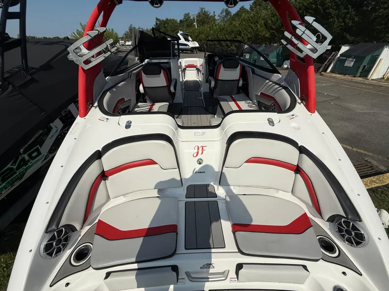 Slide: The Image of 2019 Yamaha Boats 242X E-Series interior with red and gray seating, outdoor setting. - 10